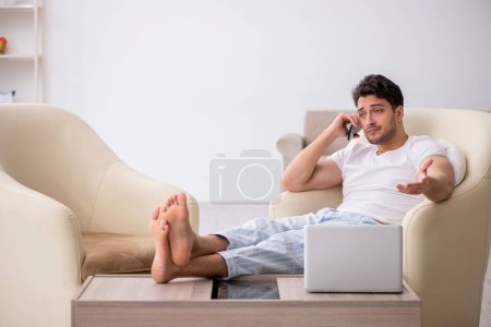 Téléchargez les photos : Jeune homme paresseux commençant la journée à la maison - en image libre de droit