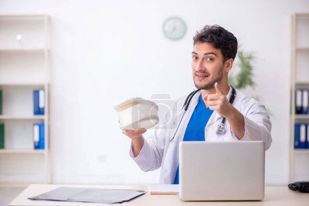 Photo for Young doctor holding neck brace in the clinic - Royalty Free Image