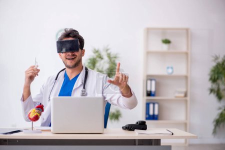 Foto de Joven médico disfrutando de gafas virtuales en la clínica - Imagen libre de derechos