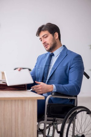 Photo for Young businessman employee in wheel-chair - Royalty Free Image