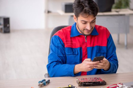 Téléchargez les photos : Jeune réparateur réparer l'ordinateur au laboratoire - en image libre de droit