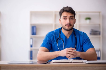 Photo for Young doctor student reading the book - Royalty Free Image