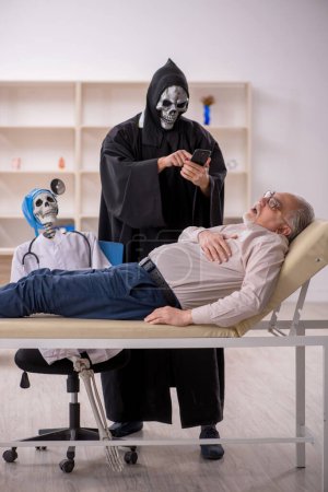 Foto de Viejo paciente visitando a dos doctores diablo - Imagen libre de derechos
