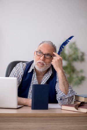 Photo for Old writer sitting at workplace - Royalty Free Image