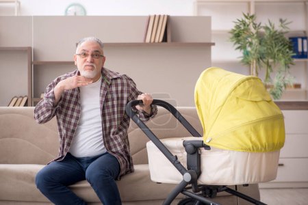 Photo for Aged man looking after newborn at home - Royalty Free Image