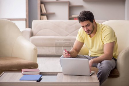 Photo for Young male student working from home during pandemic - Royalty Free Image