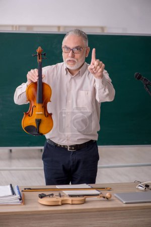 Foto de Viejo profesor tocando el violín en el aula - Imagen libre de derechos