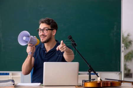 Photo for Young music teacher holding megaphone in the classroom - Royalty Free Image
