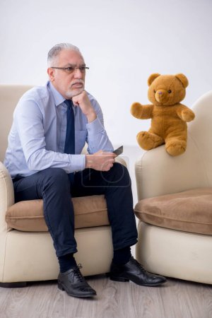 Foto de Viejo psicólogo y oso suave en la habitación - Imagen libre de derechos