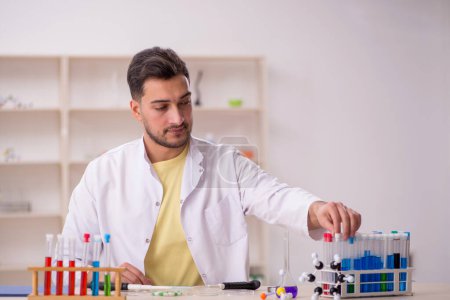 Téléchargez les photos : Young chemist sitting at the lab - en image libre de droit