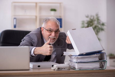 Photo for Old businessman employee eating pizza at workplace - Royalty Free Image