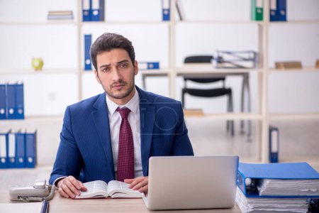 Photo for Young businessman employee reading book in the office - Royalty Free Image