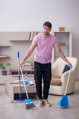Téléchargez les photos : Jeune entrepreneur nettoyage de la maison - en image libre de droit