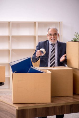 Téléchargez les photos : Ancien employé d'affaires dans le concept de déménagement de bureau - en image libre de droit