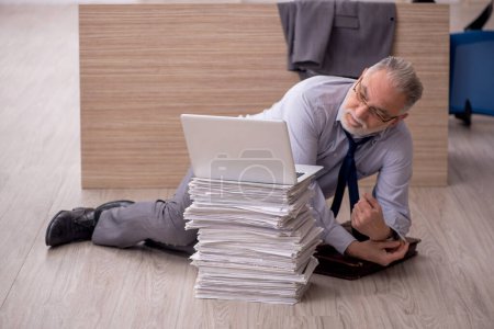 Téléchargez les photos : Vieil homme d'affaires employé et trop de travail dans le bureau - en image libre de droit