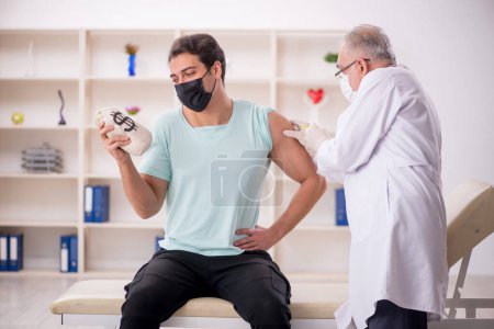 Photo for Male patient giving moneybag to male doctor - Royalty Free Image