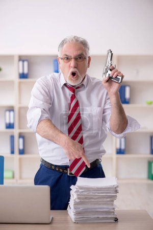 Téléchargez les photos : Old employee unhappy with excessive work at workplace - en image libre de droit