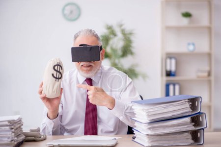 Téléchargez les photos : Vieil employé portant des lunettes virtuelles et tenant sac d'argent - en image libre de droit