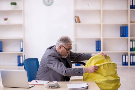 Téléchargez les photos : Un vieil homme d'affaires qui s'occupe d'un nouveau-né au bureau - en image libre de droit