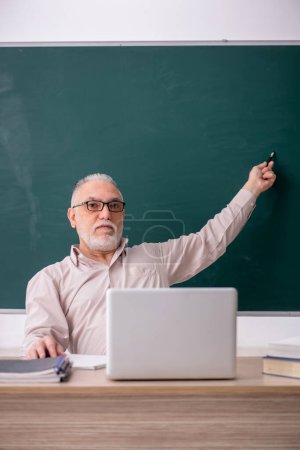 Photo for Old teacher sitting in the classroom - Royalty Free Image