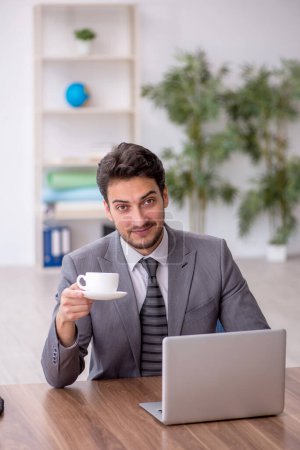 Téléchargez les photos : Jeune employé buvant du café pendant la pause - en image libre de droit