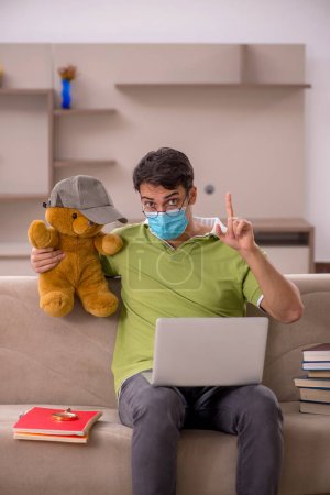 Téléchargez les photos : Jeune étudiant se préparant aux examens à domicile pendant la pandémie - en image libre de droit