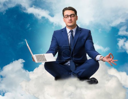 Téléchargez les photos : L'homme d'affaires qui travaille sur un ordinateur portable dans le ciel - en image libre de droit