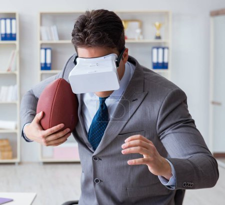 Téléchargez les photos : Homme d'affaires jouant au football de réalité virtuelle au bureau avec masque VR - en image libre de droit