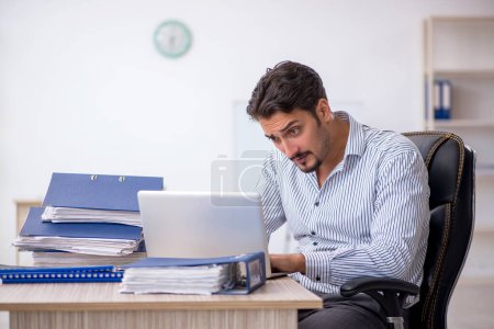 Photo for Young businessman and too much work in the office - Royalty Free Image