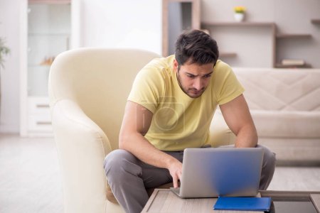 Photo for Young male student working from home during pandemic - Royalty Free Image