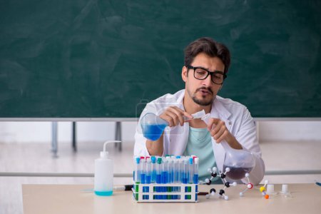 Photo for Young chemist in front of blackboard - Royalty Free Image