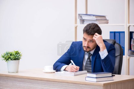 Foto de Joven empleado masculino que trabaja en la oficina - Imagen libre de derechos