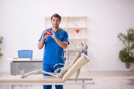Téléchargez les photos : Young doctor and skeleton patient at the hospital - en image libre de droit