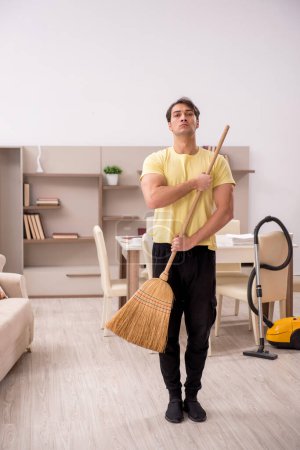 Téléchargez les photos : Jeune homme nettoyer la maison - en image libre de droit