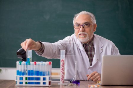 Foto de Old teacher chemist sitting in the classroom - Imagen libre de derechos
