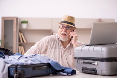 Foto de Aged man preparing for trip at home - Imagen libre de derechos