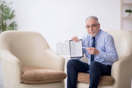 Foto de Viejo psicólogo masculino sentado en un sillón - Imagen libre de derechos