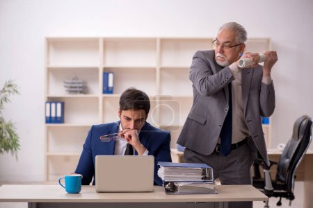 Téléchargez les photos : Ancien patron et jeune employé dans le bureau - en image libre de droit