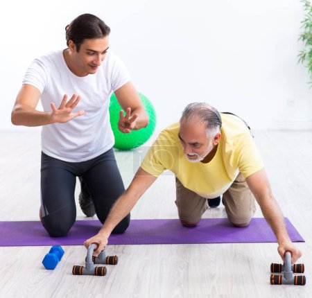 Photo for The old man doing exercises indoors - Royalty Free Image