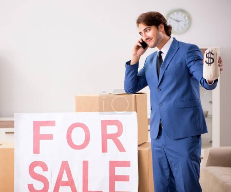 Téléchargez les photos : Le jeune beau courtier immobilier vendant appartement - en image libre de droit