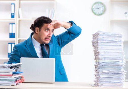 Photo for The young male employee unhappy with excessive work - Royalty Free Image