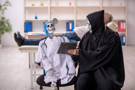Photo for Two devil doctors examining old patient - Royalty Free Image