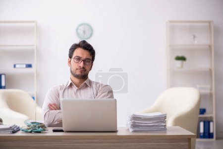 Téléchargez les photos : Young accountant sitting at workplace - en image libre de droit