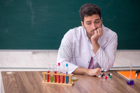Photo for Young chemistry teacher sitting in the classroom - Royalty Free Image