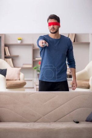 Foto de Hombre con los ojos vendados viendo la televisión en casa - Imagen libre de derechos