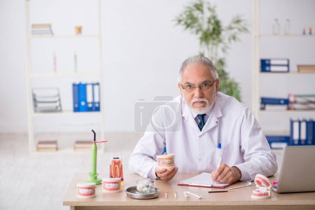 Photo for Old male doctor dentist working at the hospital - Royalty Free Image