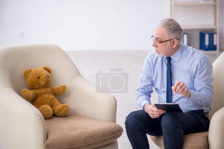 Foto de Viejo psicólogo y oso suave en la habitación - Imagen libre de derechos