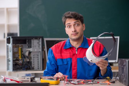 Téléchargez les photos : Jeune réparateur réparer des ordinateurs dans la salle de classe - en image libre de droit