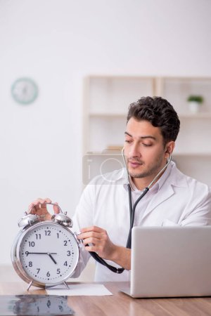Photo for Young doctor in time management concept - Royalty Free Image