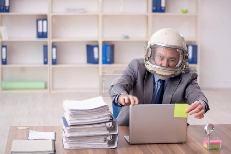 Téléchargez les photos : Old employee wearing spacesuit in the office - en image libre de droit